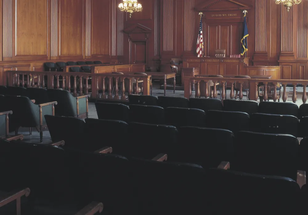 The public gallery of a wood-panelled courtroom facing the judge’s bench